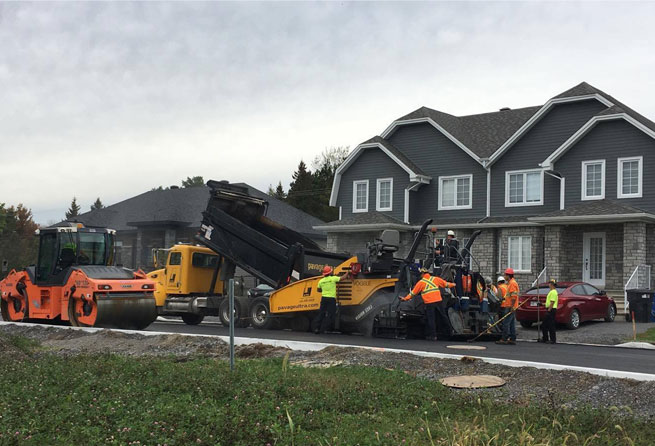 Travaux d'asphaltages et de compactages sur une rue résidentielle