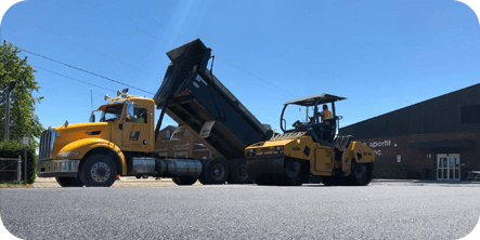 Camion réalisant un travail d'asphaltage sur une rue commercial