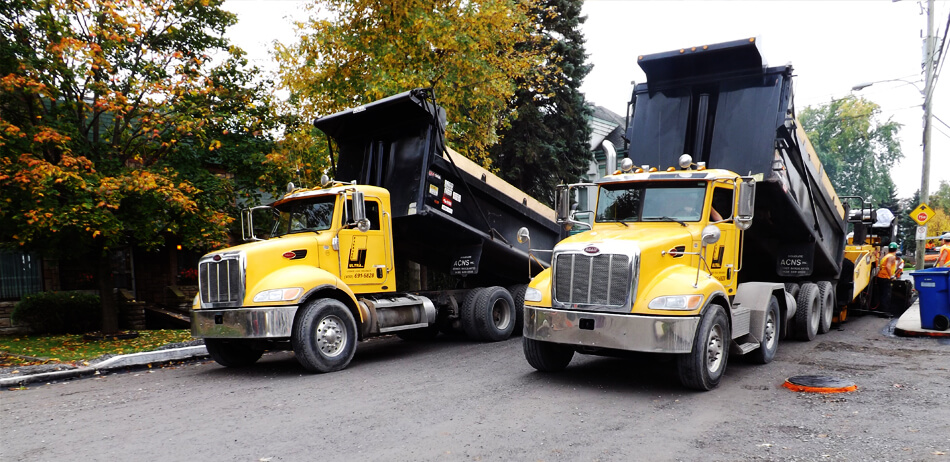 Deux camions effectuant le chargement d'asphalte