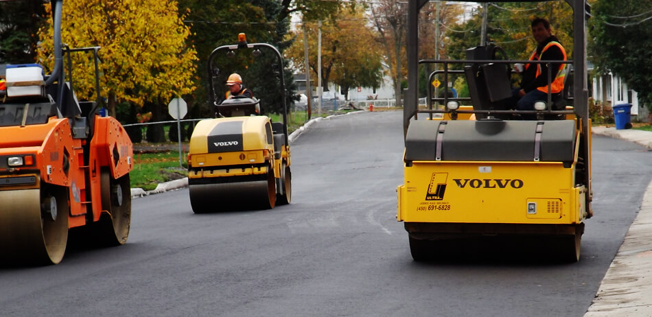 trois rouleaux compacteurs sur la rue